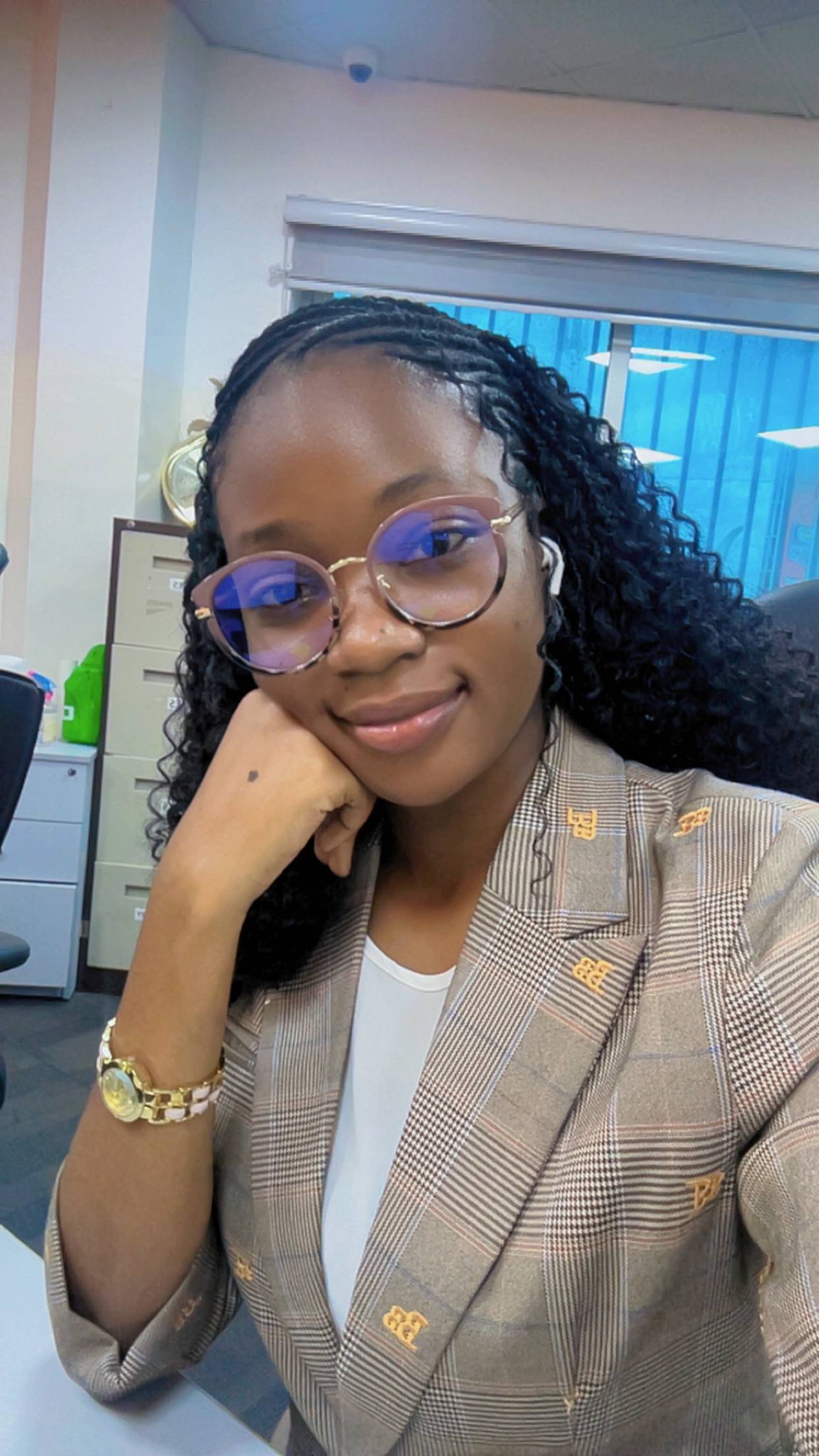 person with glasses hand resting on chin wearing a blazer